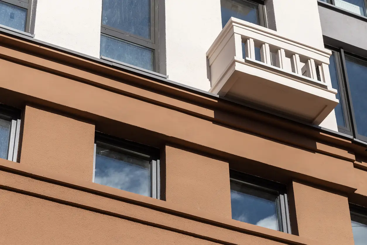 Facade plaster background. Single-ply monolithic plaster decorative background. Single layer scraped cement plaster wallpaper. Exterior building structure backdrop.