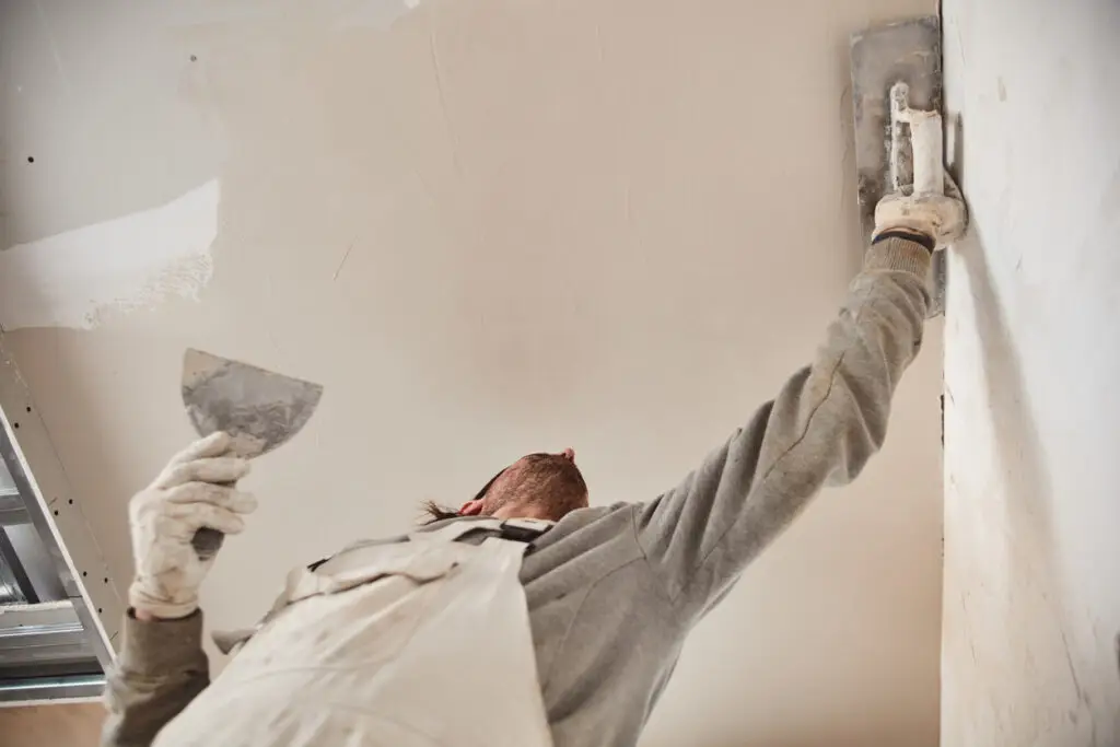 Handwerker verputzt eine Gipswand im Innenbereich eines Hauses – professionelle Innenputzarbeiten von Stuck Becker aus Bonn.