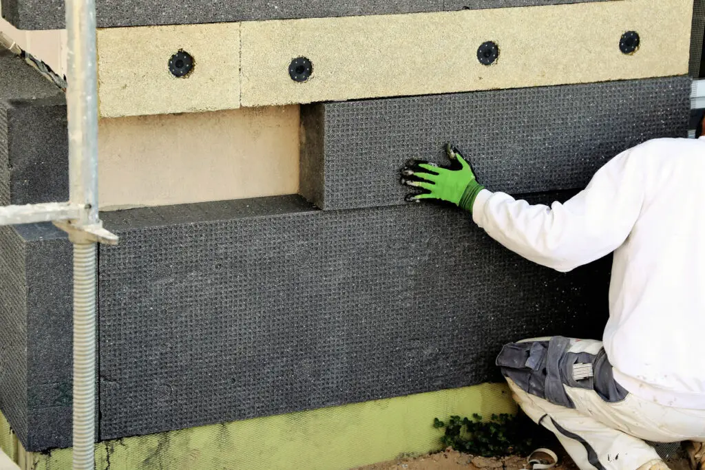 Bauarbeiter bei der Fassadendämmung eines Wohnhauses – Montage von Dämmplatten im Rahmen einer energetischen Sanierung in Bonn durch Stuck Becker.